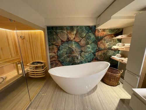 a bathroom with a large tub and a mosaic wall at Luxuriöses Loft mit großer Sonnenterrasse & Sauna in Munich