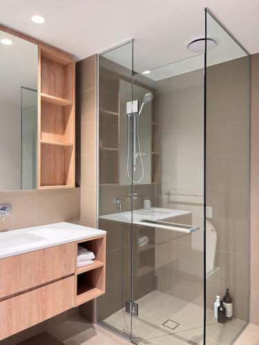 W łazience znajduje się szklana kabina prysznicowa i umywalka. w obiekcie Style City Apartment Living ! w Melbourne