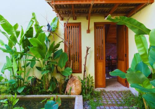 a house with an open door and some plants at Faifo Retreat Villa Hội An in An Bang