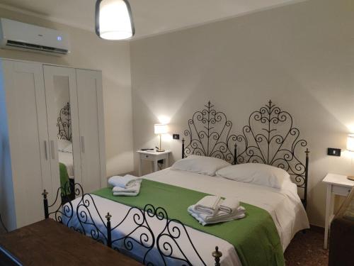 a bedroom with a large bed with green and white sheets at B&B NONNA GINA in Manoppello