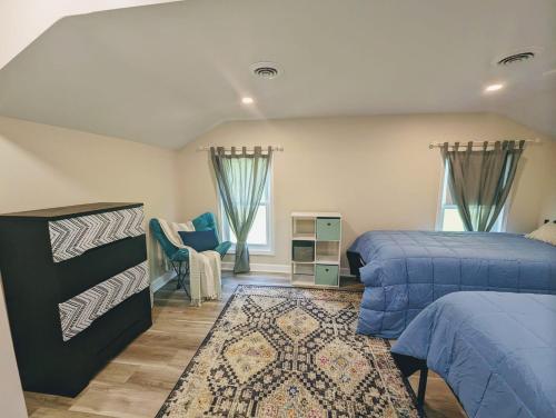 1 Schlafzimmer mit 2 Betten und einem Teppich in der Unterkunft Flushing Centennial Farmhouse in Flint