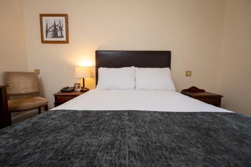 Una cama o camas en una habitación de Castle and Ball by Greene King Inns