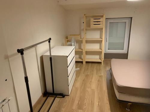 Zimmer mit einem Bett und einem Kühlschrank. in der Unterkunft Jolie T3 / Emplacement Ideal in Le Pouzin