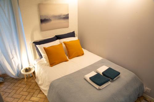 sypialnia z łóżkiem z żółtymi i niebieskimi poduszkami w obiekcie Petit Studio Secret - Coeur de Provence - 4 personnes w mieście Volx