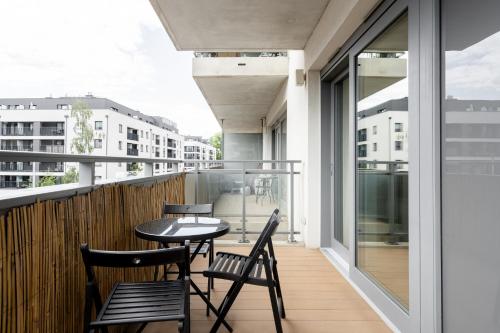 a balcony with chairs and a table on a building at RentPlanet - Kępa Mieszczańska in Wrocław
