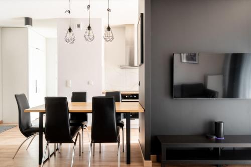 a dining room with a table and black chairs at RentPlanet - Kępa Mieszczańska in Wrocław