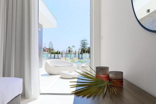 a bathroom with a toilet and a large window at NAPA GEM SUITES by LUXEL VILLAS in Ayia Napa