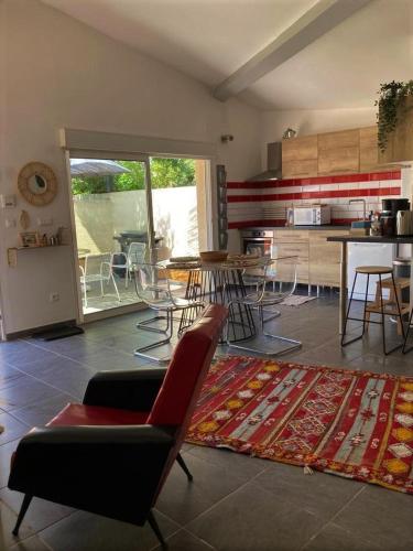 un salon avec une table et des chaises et une cuisine dans l'établissement Correspondances la Colette Pont Du Gard, à Fournès