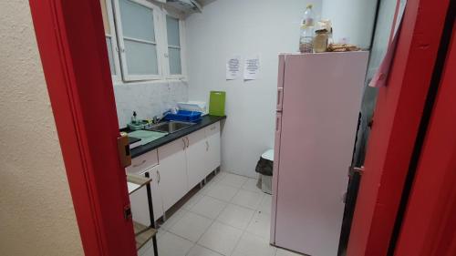 a kitchen with a sink and a white refrigerator at La Merced Centro Rooms in Málaga