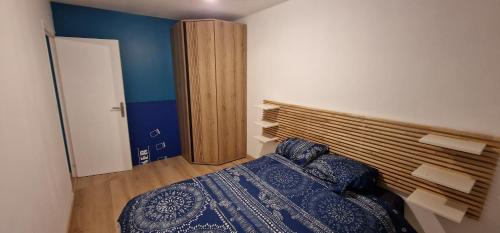 a bedroom with a bed and a wooden headboard at L'Echo des Vagues in Le Havre