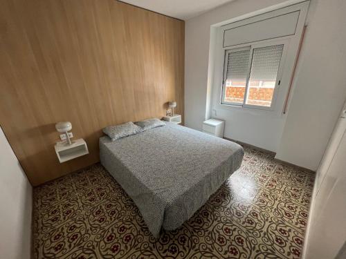 a small bedroom with a bed and a window at El Bull de Baix a Mar in Torredembarra
