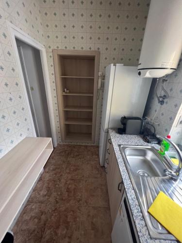 a small kitchen with a sink and a refrigerator at El Bull de Baix a Mar in Torredembarra