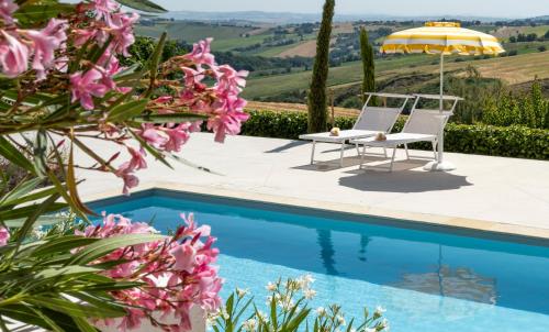 uma villa com uma piscina, uma cadeira e um guarda-sol em Vecchi Maestri Bed & Breakfast em Arcevia