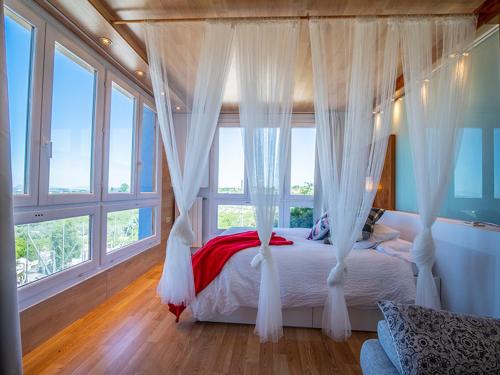 1 dormitorio con cama con dosel y cortinas blancas en Atico Deluxe Solano Especial Parejas, en Moratalla