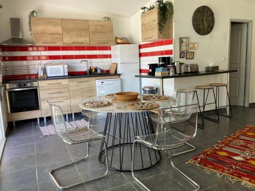 une cuisine avec une table et des chaises dans l'établissement Correspondances la Colette Pont Du Gard, à Fournès