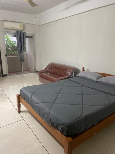 1 dormitorio con cama y sofá de cuero en Viriyapon, en Bangkok