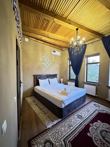 sypialnia z łóżkiem i żyrandolem w obiekcie Darvozai Samarkand guest house w Samarkandzie