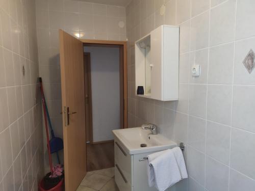 een badkamer met een toilet, een wastafel en een spiegel bij Apartments Dijana in Krk