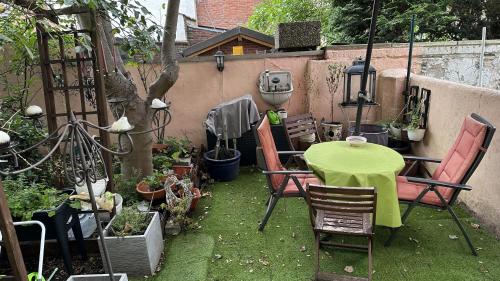 a patio with a table and chairs in a garden at Appartment First in Duisburg