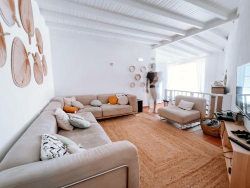 a white living room with a couch and a chair at Quinta de São Pedro de Tomar in Tomar