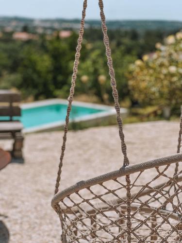 a basket hanging from a rope in front of a pool at Quinta de São Pedro de Tomar in Tomar