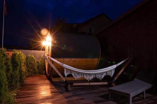a hammock sitting on a patio at night at Apartamenty całoroczne "Eleganza" jacuzzi-sauny in Nadole