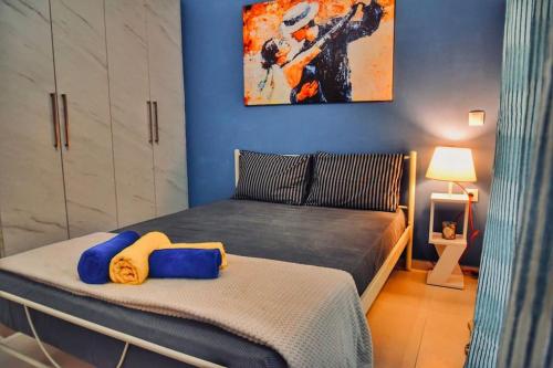 1 dormitorio con 1 cama con pared azul en Perseas House, en Argos