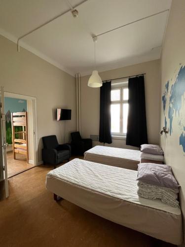 Habitación de hotel con 2 camas y ventana en Carlstad Sport Hostel, en Karlstad