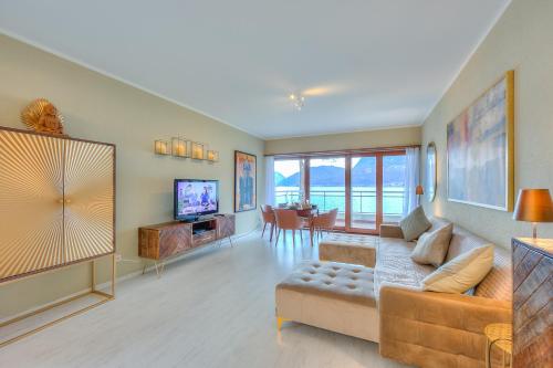 a living room with a couch and a tv at Emotion Lake View - Happy Rentals in Capolago
