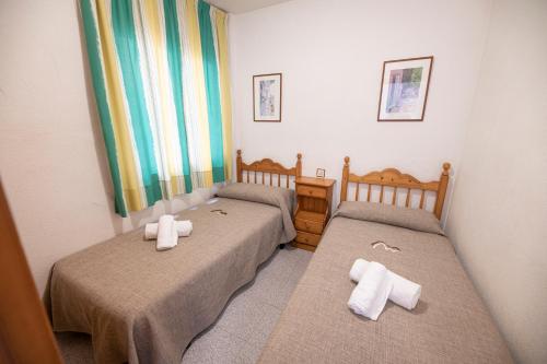 two beds in a small room with towels on them at Destino De Sol De Los Alcazares in Los Alcázares