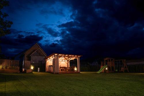 a tent in a yard at night with a playground at Apartamenty całoroczne "Eleganza" jacuzzi-sauny in Nadole