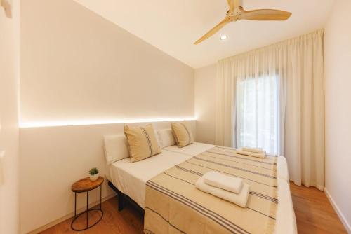 Habitación blanca con cama y ventana en Bravissimo Devesa, 3 bedrooms and near the parc, en Girona