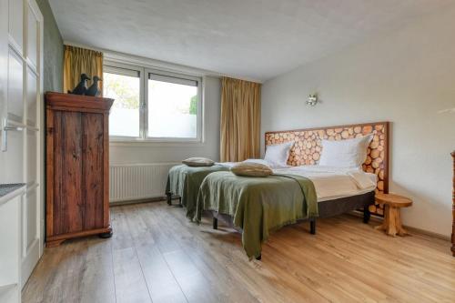 a bedroom with two beds and a window at Borneman Buitenhof - Privé Appartement in Houten