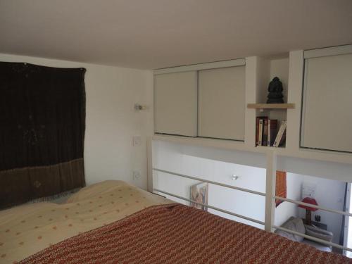 a bedroom with a bed and white cabinets at Joli studio de 30m2 in Villeneuve