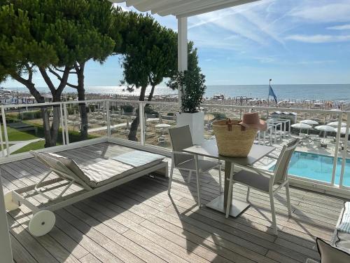 uma mesa e cadeiras num deque com vista para a praia em Hotel Ril em Lido di Jesolo