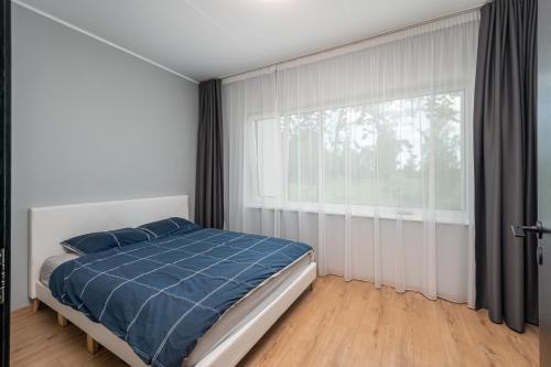 1 dormitorio con cama y ventana grande en Ladva 10, en Tartu
