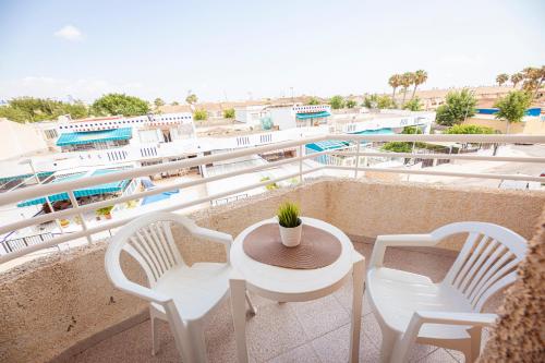 a balcony with a table and chairs and a pool at Destinos De Sol Los Alcazares - Montepío Minería in Los Alcázares