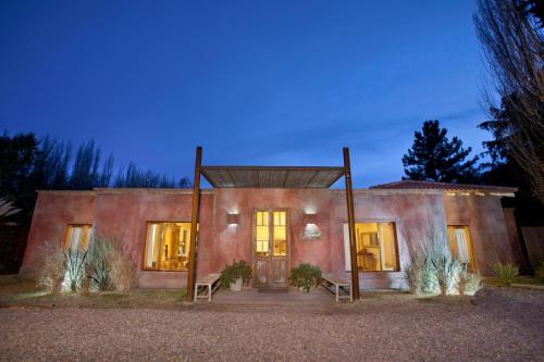 a house with a lit up front of it at Posada Borravino in Chacras de Coria