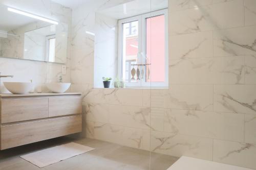 a white bathroom with two sinks and a window at Le Tropical, Chic & Design in Wahlbach