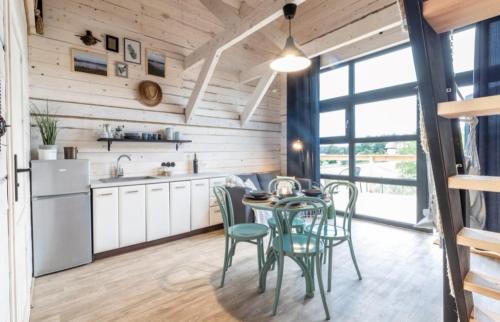 a kitchen and dining room with a table and chairs at Mazury Holiday Cottage in Piecki