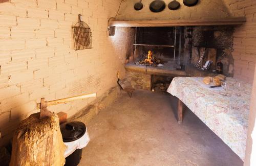 Una habitación con chimenea y una cama en una habitación en A Casa De Lucha, en Meis