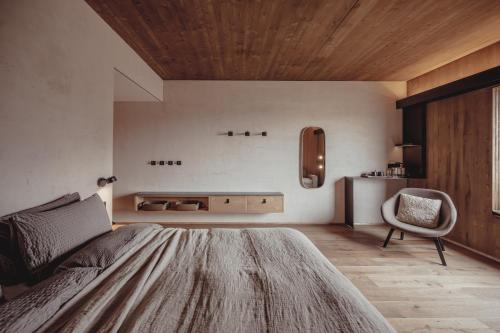 a bedroom with a bed and a chair in it at Highland Base Kerlingarfjöll in Kerlingarfjoll