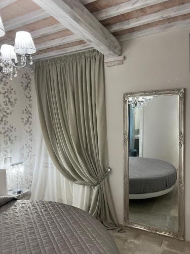 a bedroom with a mirror and a bed in it at L’ Aia del Principe in Montepulciano