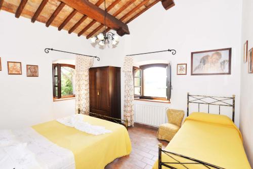 a bedroom with two beds and a chair at Agriturismo Sant'Angelo in Acquapendente