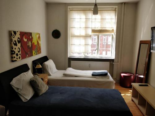 a bedroom with two beds and a window at Guesthouse Copenhagen in Copenhagen