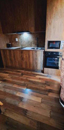 a kitchen with a wooden floor and a stove at The World Apartament II in Târgu-Mureş