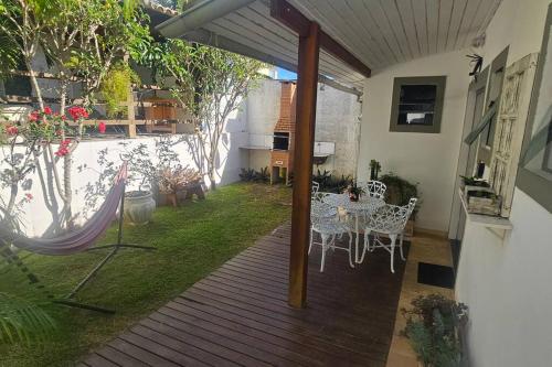 un patio con mesa y sillas en una terraza en Apartamento Ambar, en Búzios