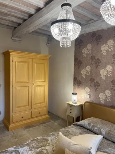 a bedroom with a bed and two chandeliers at L’ Aia del Principe in Montepulciano