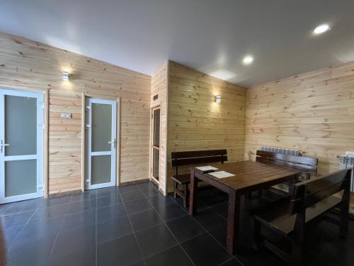 a dining room with wooden walls and a wooden table and benches at Barvy Dnipra in Dnipro