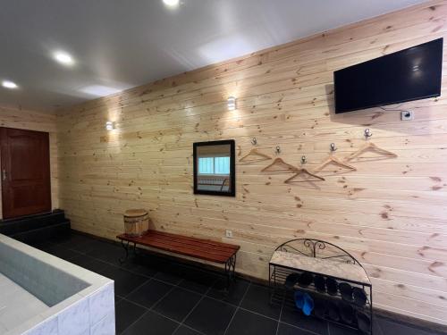 a room with a wooden wall with a bench and a flat screen tv at Barvy Dnipra in Dnipro